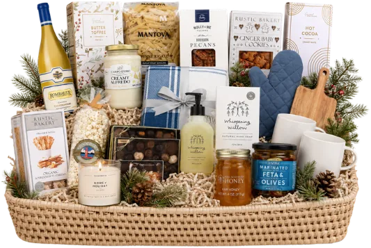 Woven rattan tray holding a bottle of chardonnay, pasta, alfredo sauce, marinated feta and olives, honey, hand soap, two ceramic cups, a cutting board and a candle